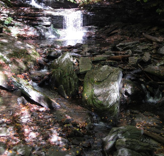 Sunlight, shadows, boulders, and a waterfall